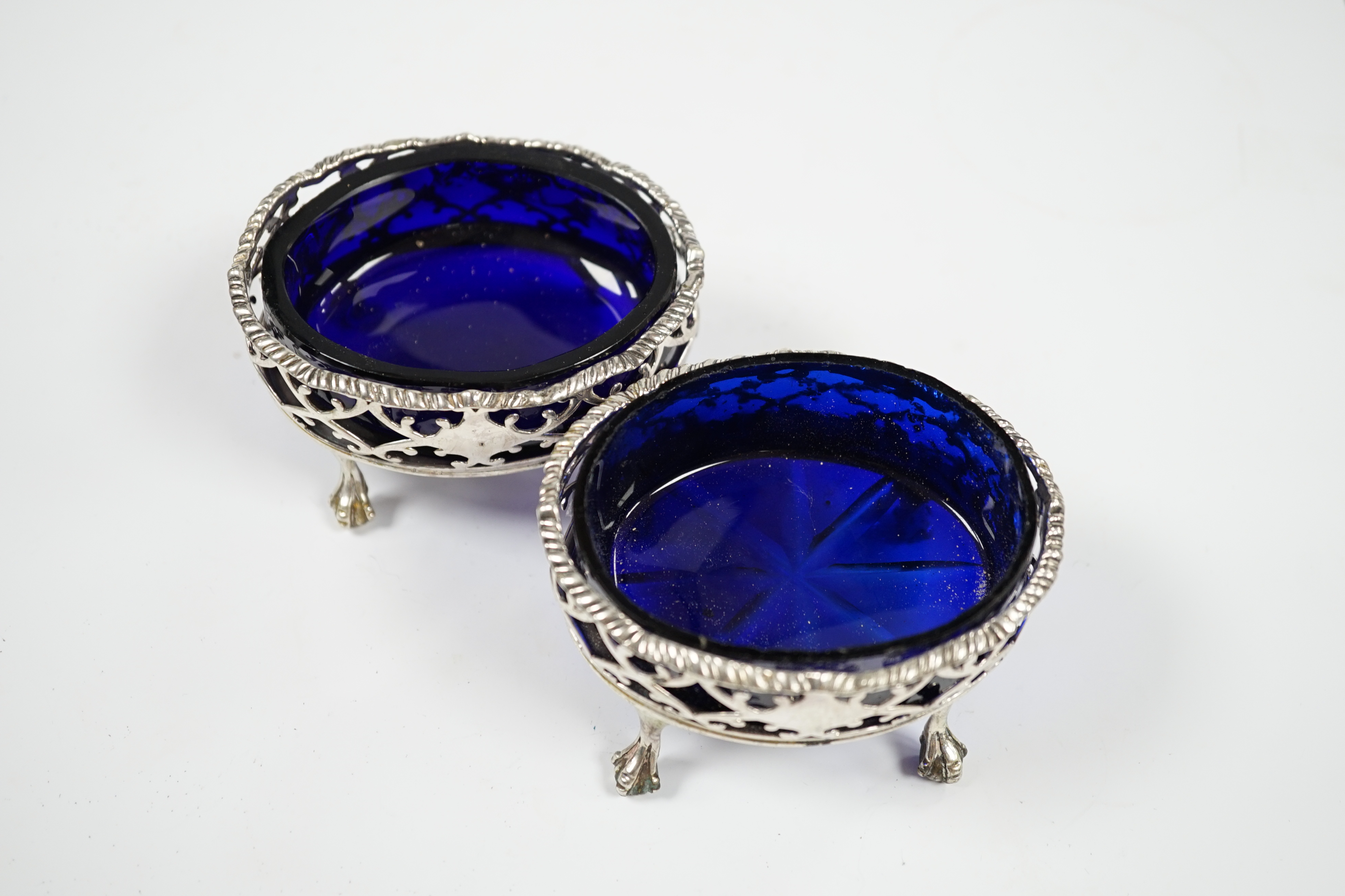 A pair of late George II pierced silver oval salts, by Robert & David Hennell I, London, 1759, with associated blue glass liners, 83mm. Condition - poor